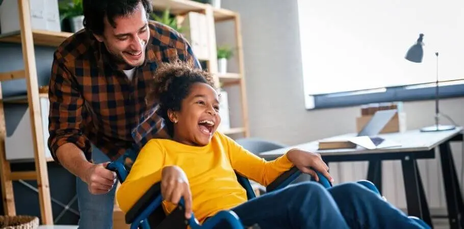 Father and his daughter who is in a wheelchair smiling and laughing