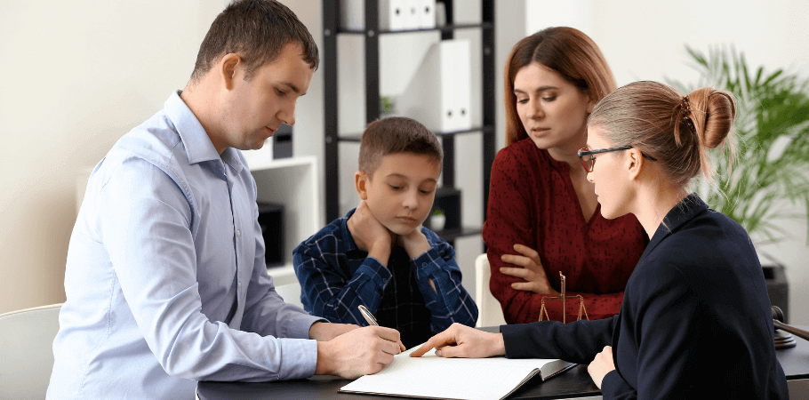 Husband signing legal documents in front of his family