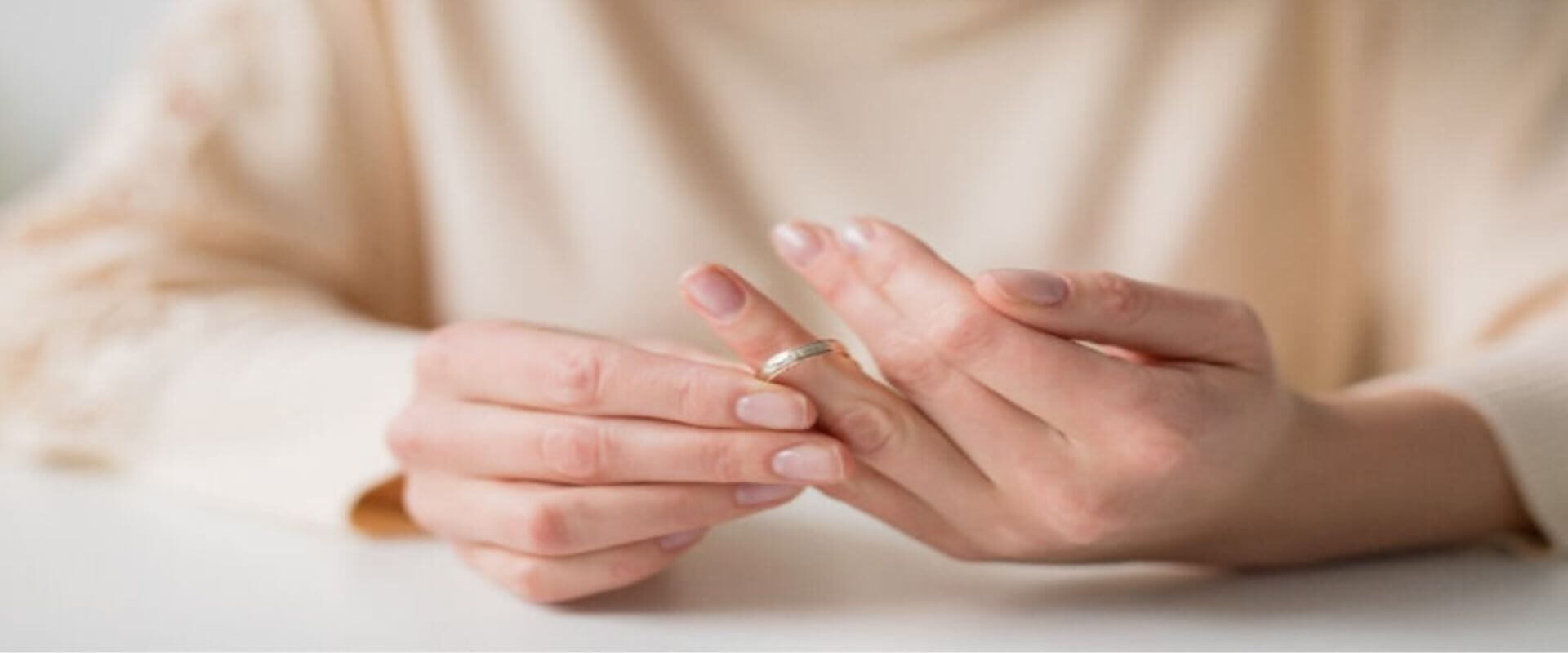 Woman removing her wedding ring from her hand
