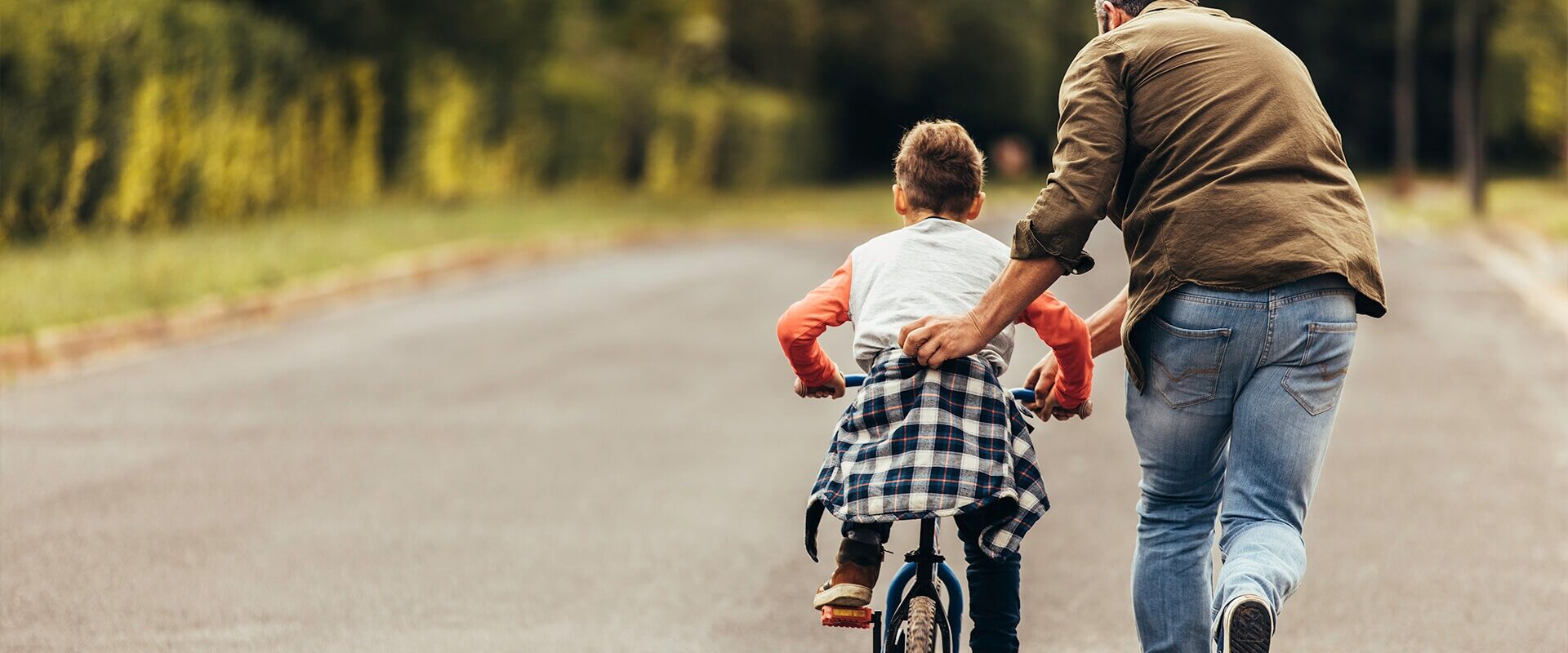 Father teaching child to ride bike