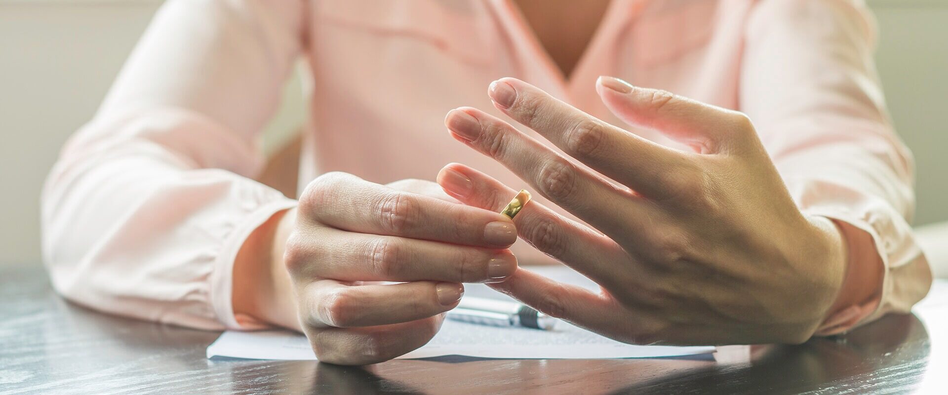 woman taking off wedding ring after divorce