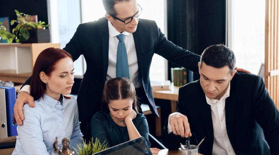 Lawyer standing behind a sad looking family