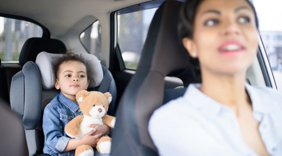 Mother driving while her daughter sits in the back seat