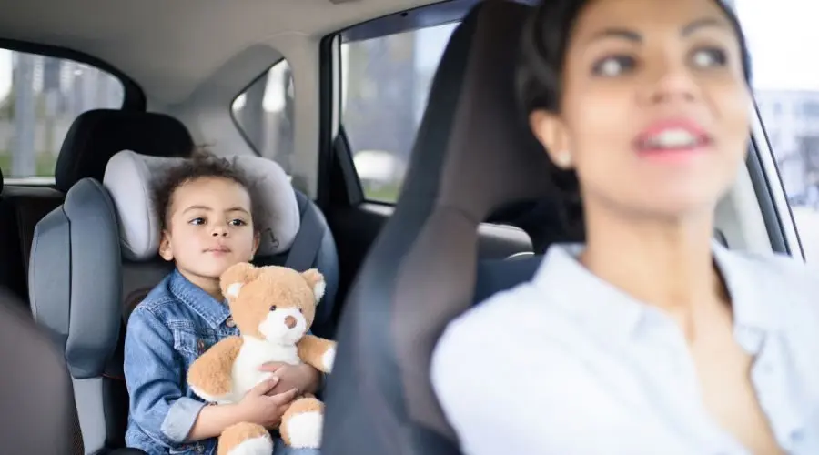 Mother driving while her daughter sits in the back seat