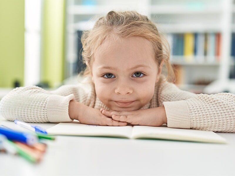 Child resting her head on a notebook