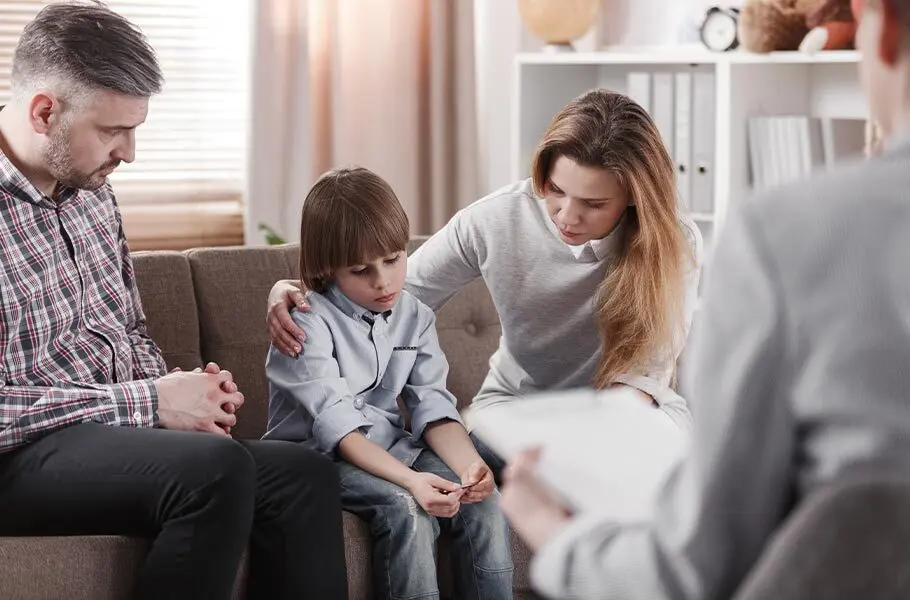 a mother and father sitting on a couch with their son