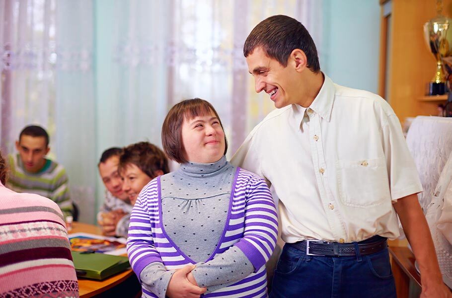 a man and woman with special needs smiling at each other.