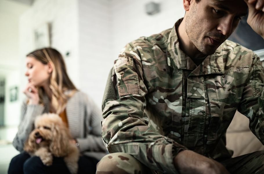 military member and wife sitting on a couch in different directions