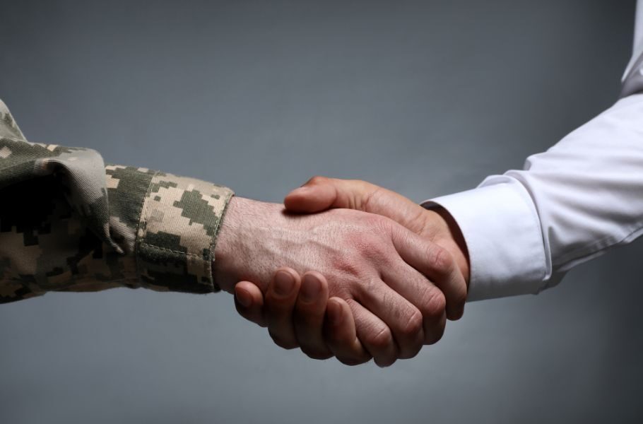 Military member shaking hands with a civilian