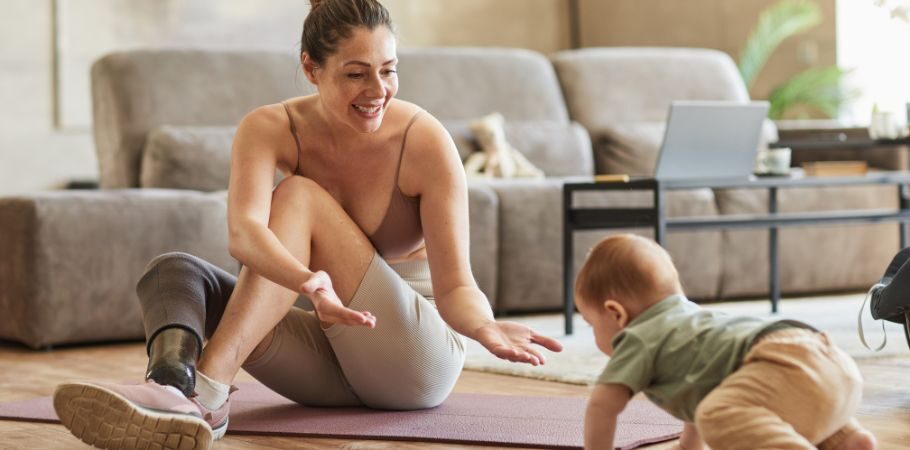 Mother with a prosthetic leg playing with her baby