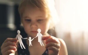 child holding paper cut outs of a family