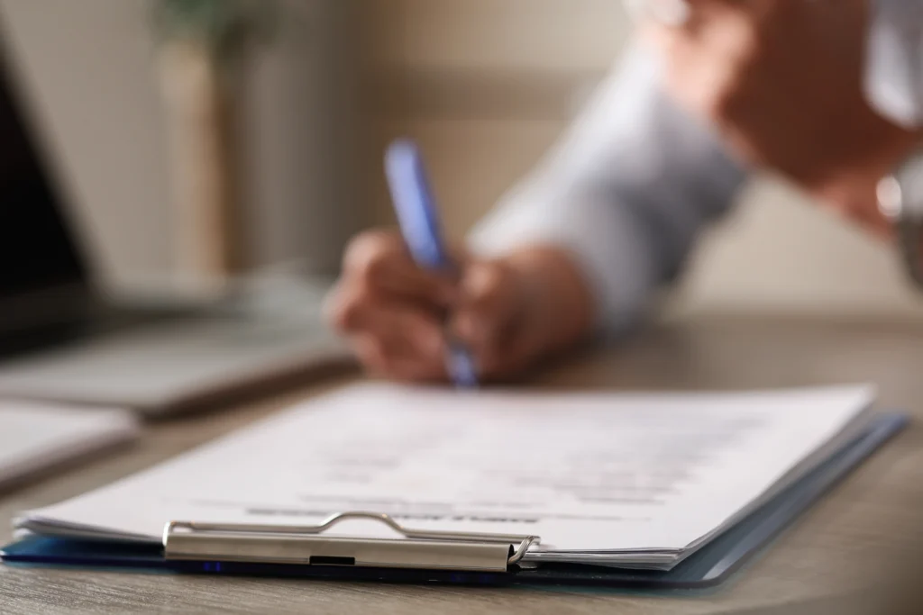 Close up unrecognizable business person signing documents office
