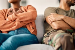 Tampa military couple on a couch, arms folded, looking away from each other.