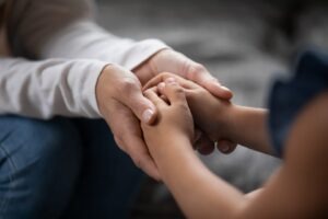 Fairfax parent discussing custody arrangements with their child while holding her hands