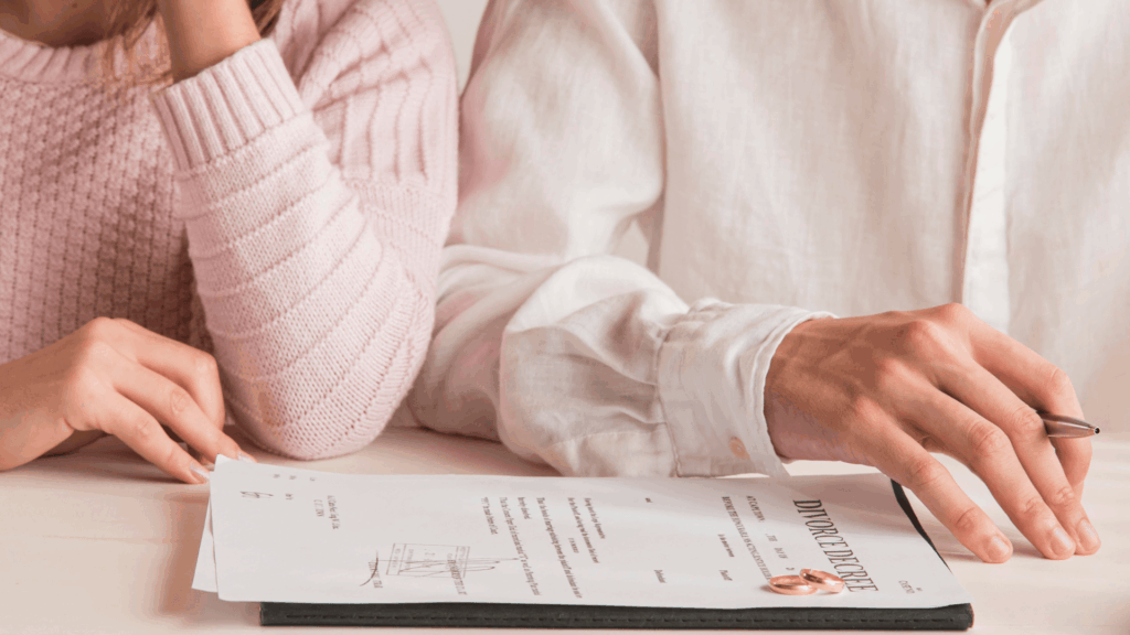 Florida Divorce Decree on table with two wedding rings on it & couple's hands