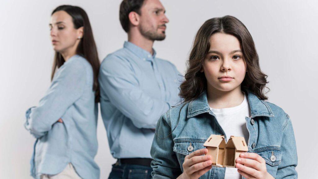 Teenager holding broken toy while parents are arguing