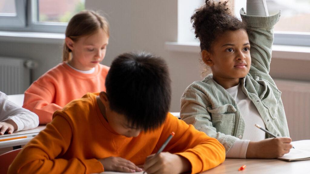 Child raising their hand in class