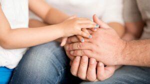 Photo of child and parent holding hands