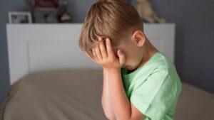 Child upset and covering his eyes
